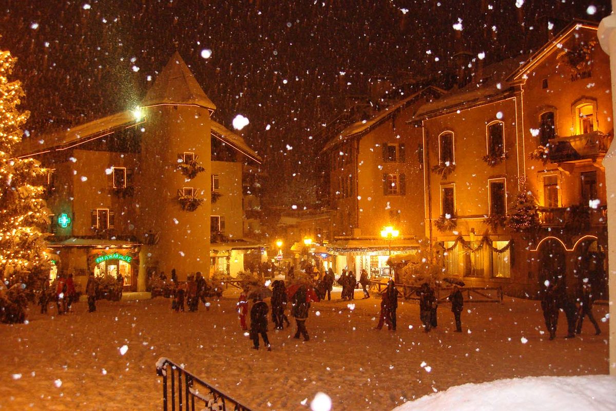 La place du village sous la neige, un soir d'hiver